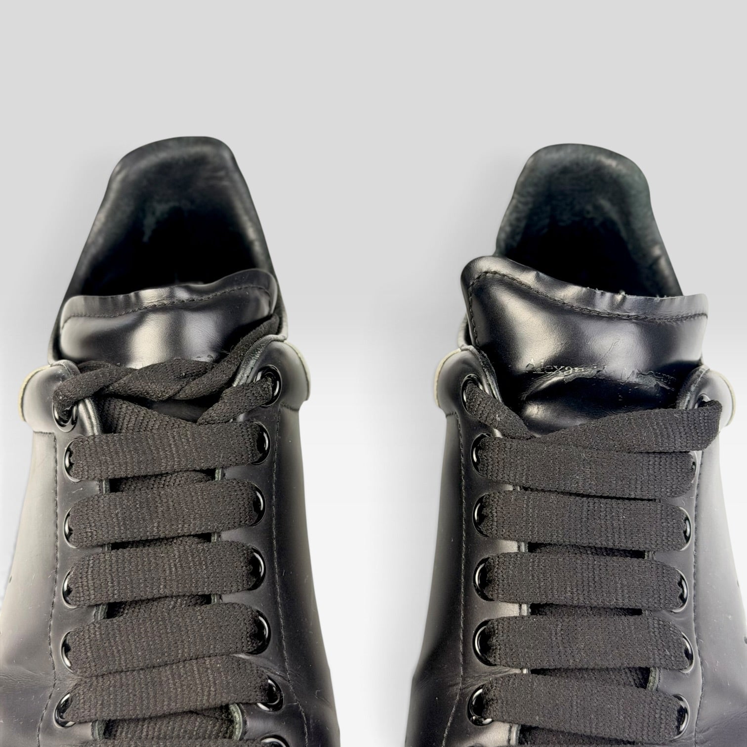 V STEALS pre-loved Alexander McQueen black leather oversized sneakers with wide laces and rounded toe design