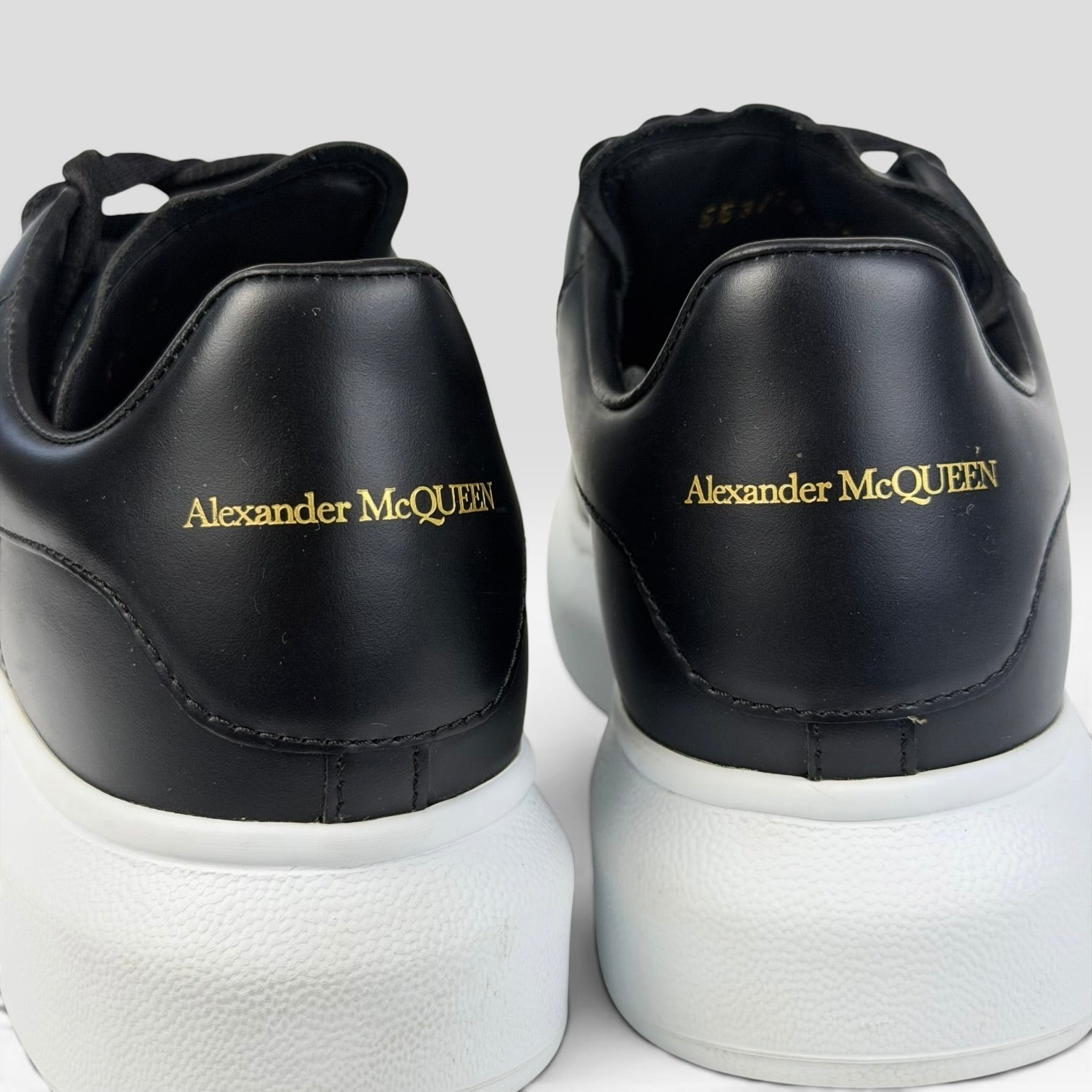 V STEALS Alexander McQueen oversized sneakers in black leather with gold logo and thick white rubber soles