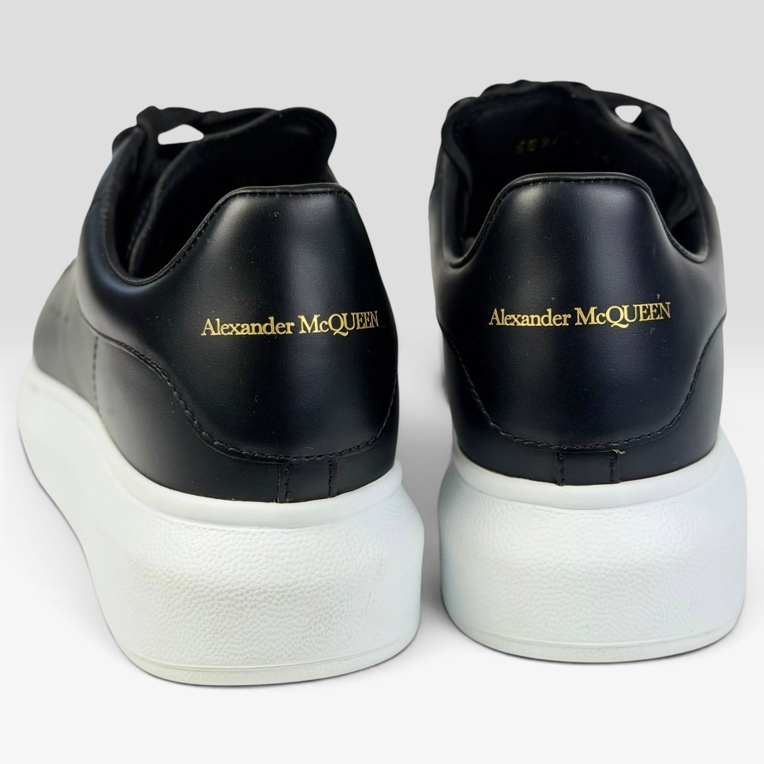 V STEALS Alexander McQueen black leather oversized sneakers with white rubber platform soles and gold logo detail