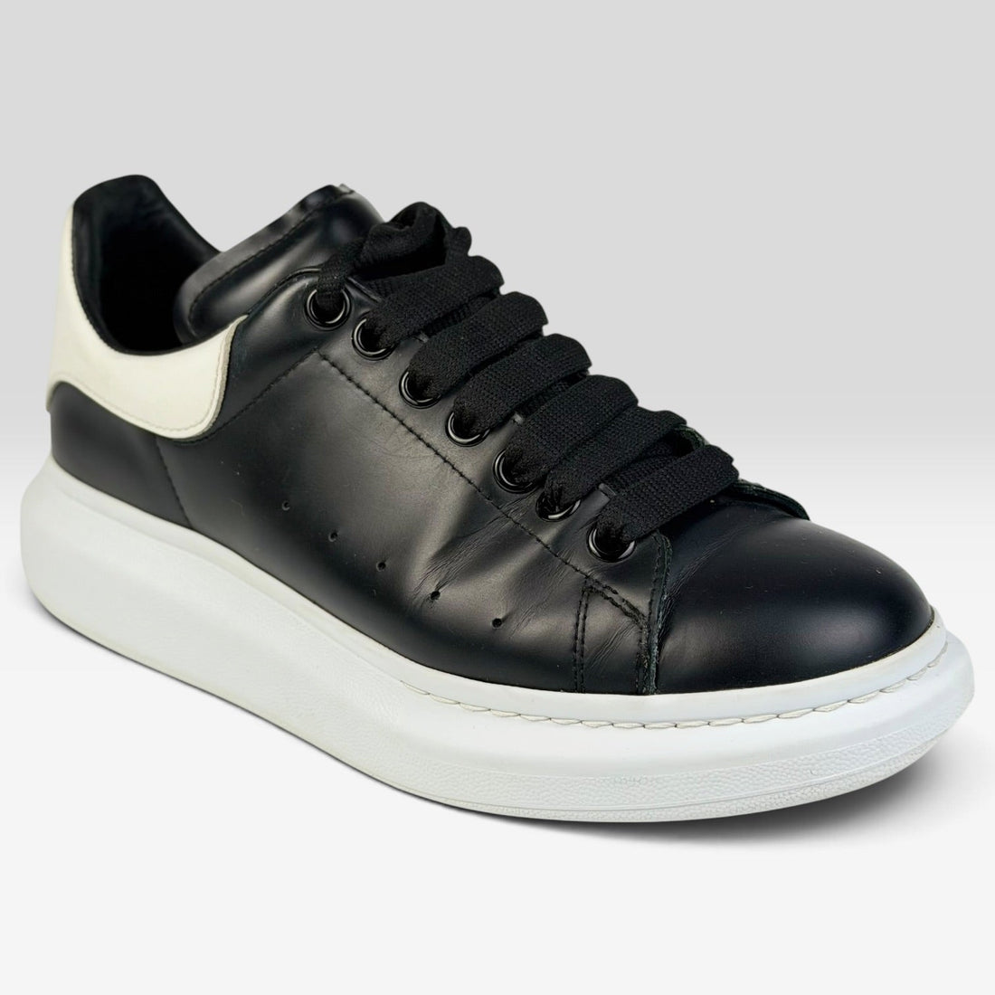 V STEALS pre-loved Alexander McQueen oversized sneakers in black leather with a chunky white rubber sole