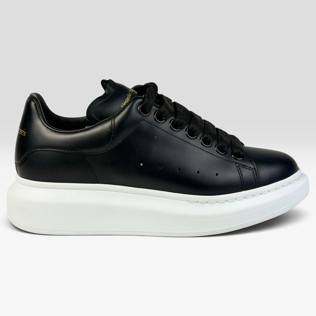 V STEALS Alexander McQueen black leather oversized sneakers with a thick white rubber platform sole and round toe.