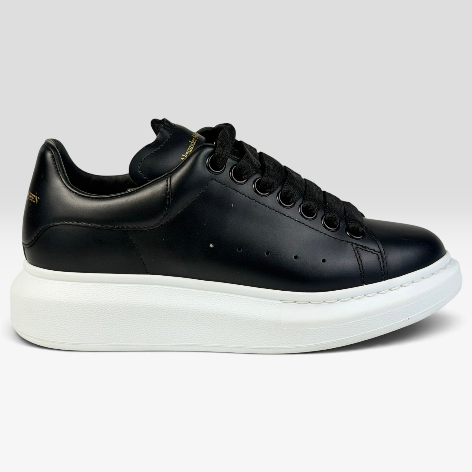 V STEALS Alexander McQueen black leather oversized sneakers with a thick white rubber platform sole and round toe.