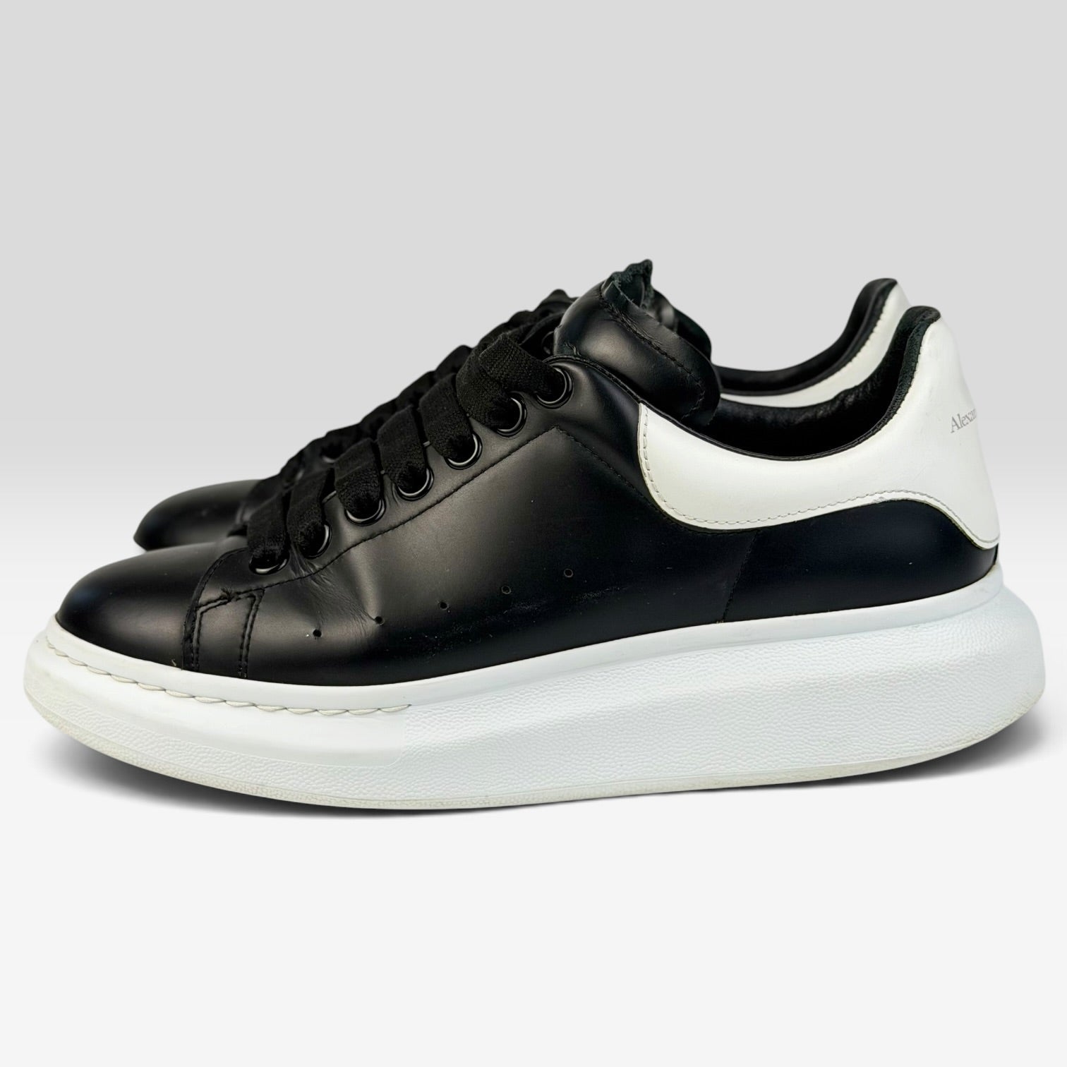 V STEALS Alexander McQueen oversized sneakers in black leather with a chunky white rubber sole and round toe.