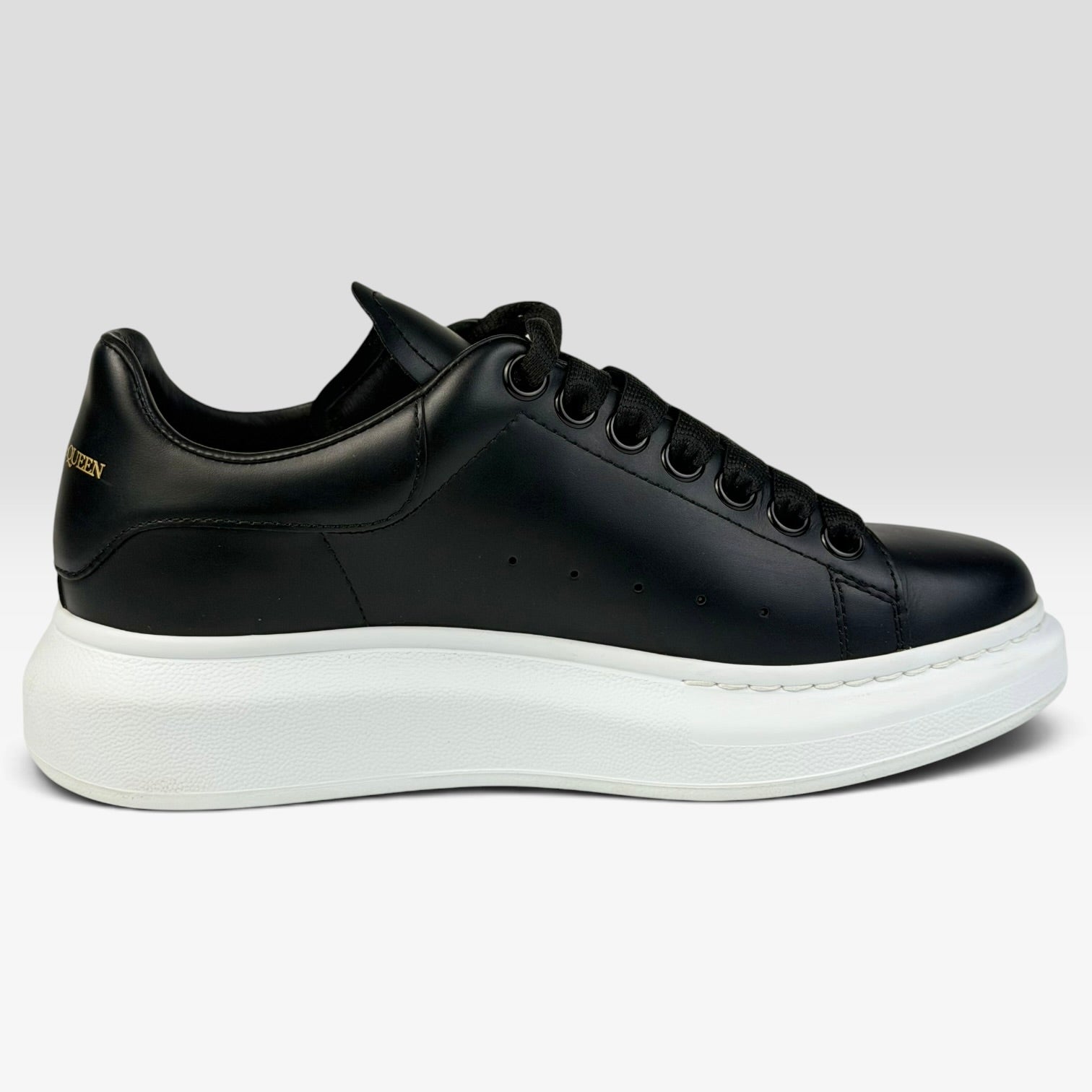 V STEALS Alexander McQueen black leather oversized sneakers with a thick white rubber platform sole and side view.