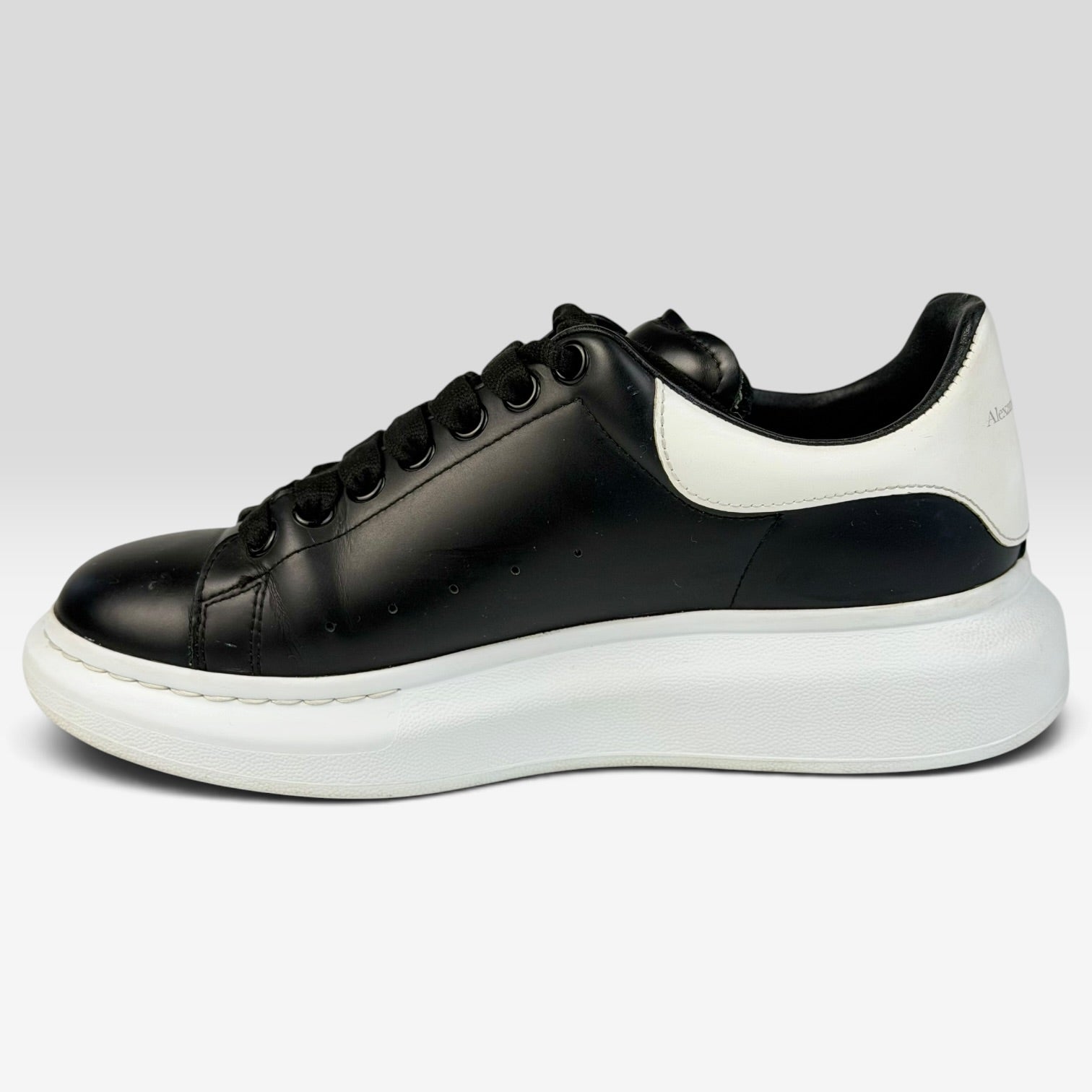 V STEALS Alexander McQueen oversized sneakers in black leather with a chunky white rubber sole and rounded toe.