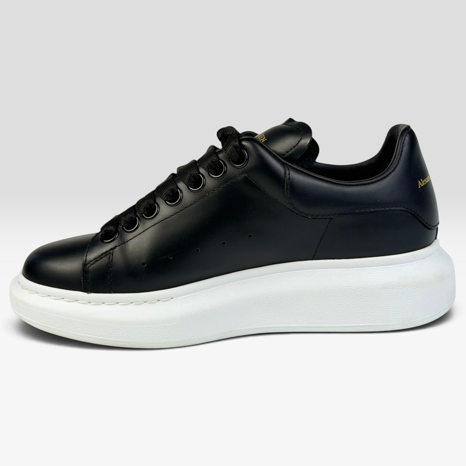 V STEALS Alexander McQueen black leather oversized sneakers with a thick white rubber sole and rounded toe.