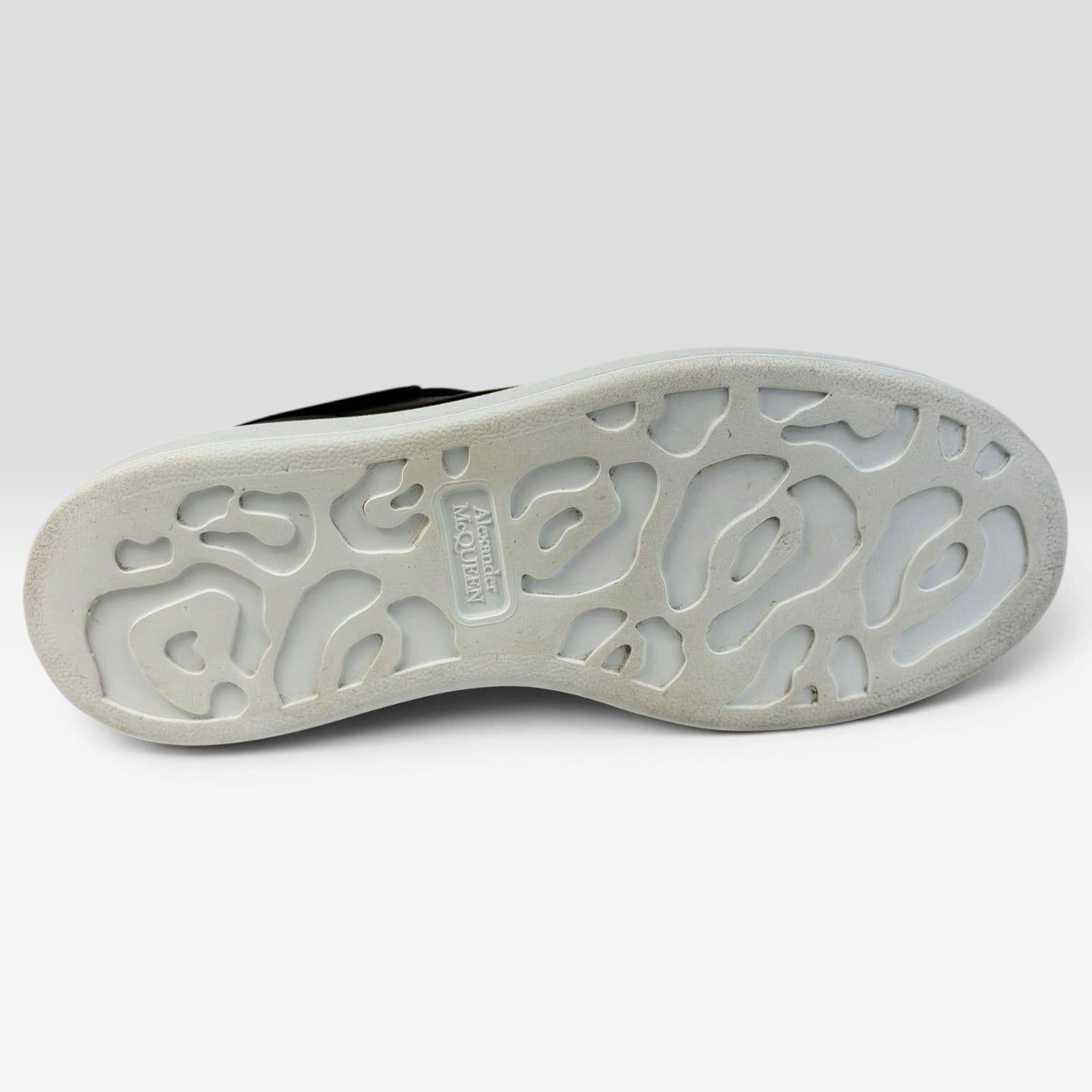 V STEALS Alexander McQueen black oversized sneakers showing the white rubber outsole with embossed logo pattern