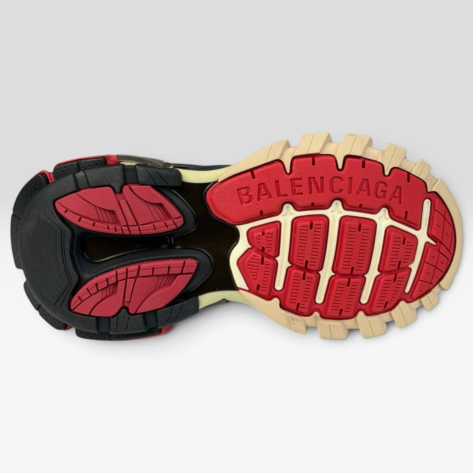 V STEALS Balenciaga Track Bred sneaker outsole in red, black, and beige with aggressive lug tread and branding.
