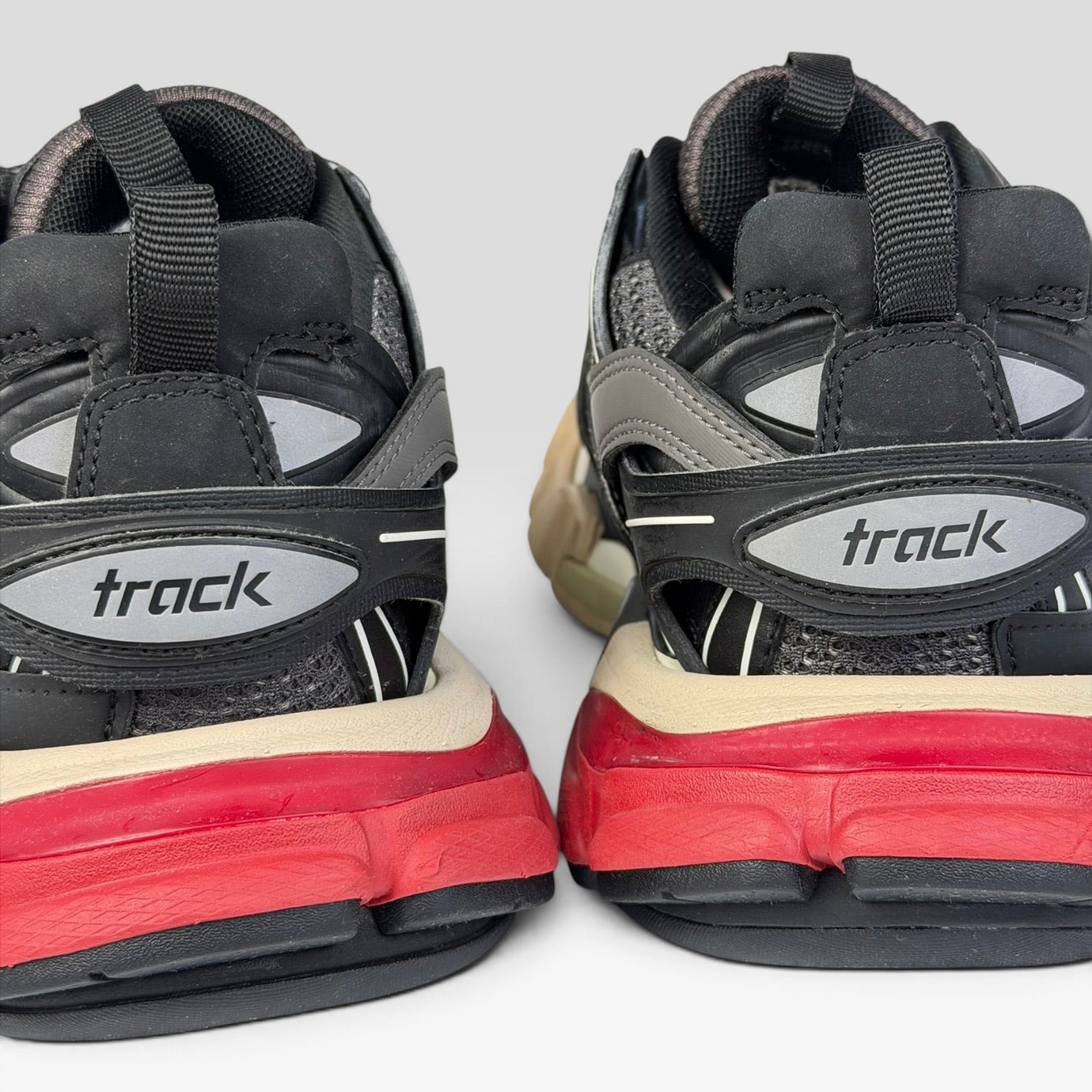 V STEALS Balenciaga Track Bred sneakers showing the rear view with red soles, black mesh, and reflective track logos.