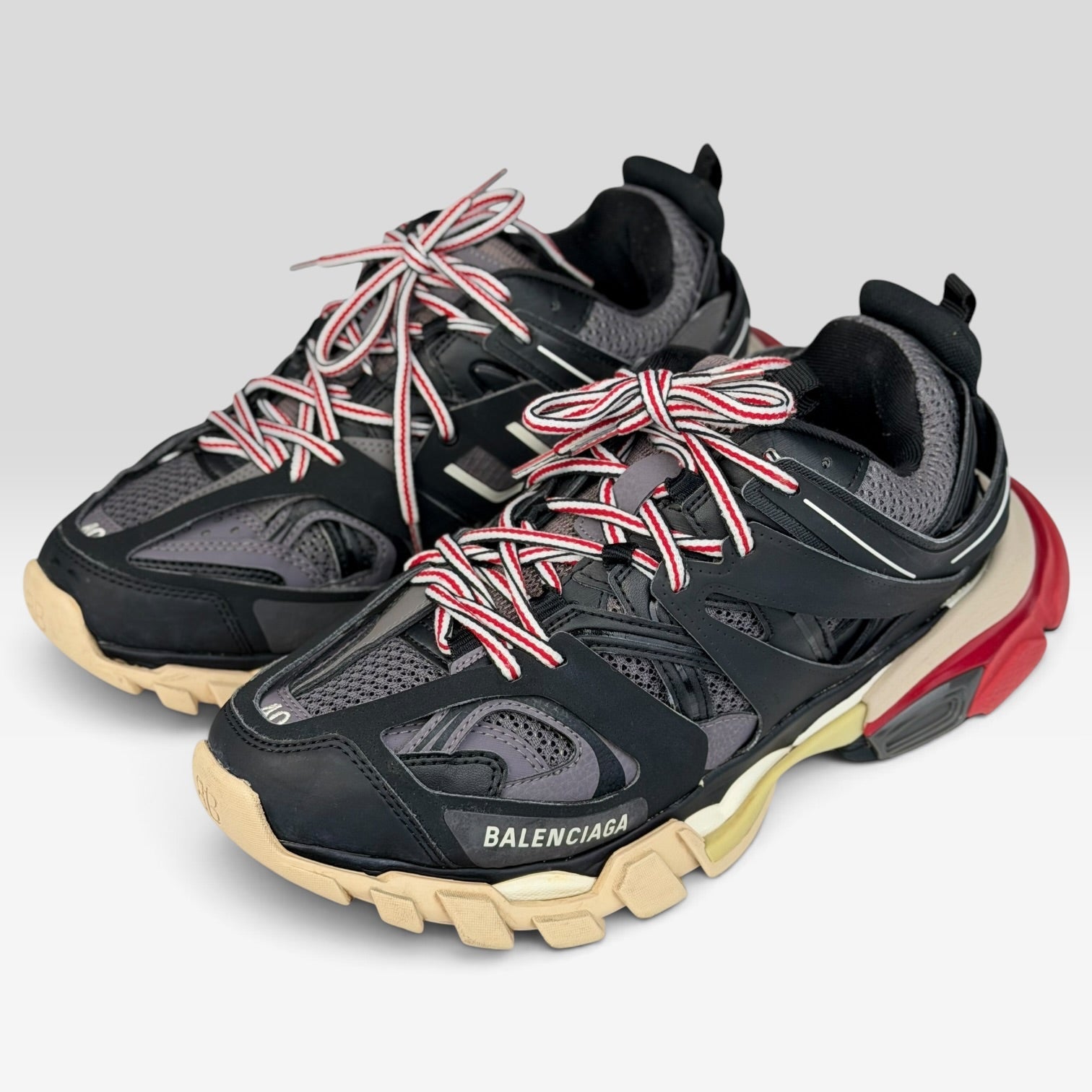 V STEALS Balenciaga Track Bred sneakers in black and red with technical mesh, layered caging, and chunky lug sole.