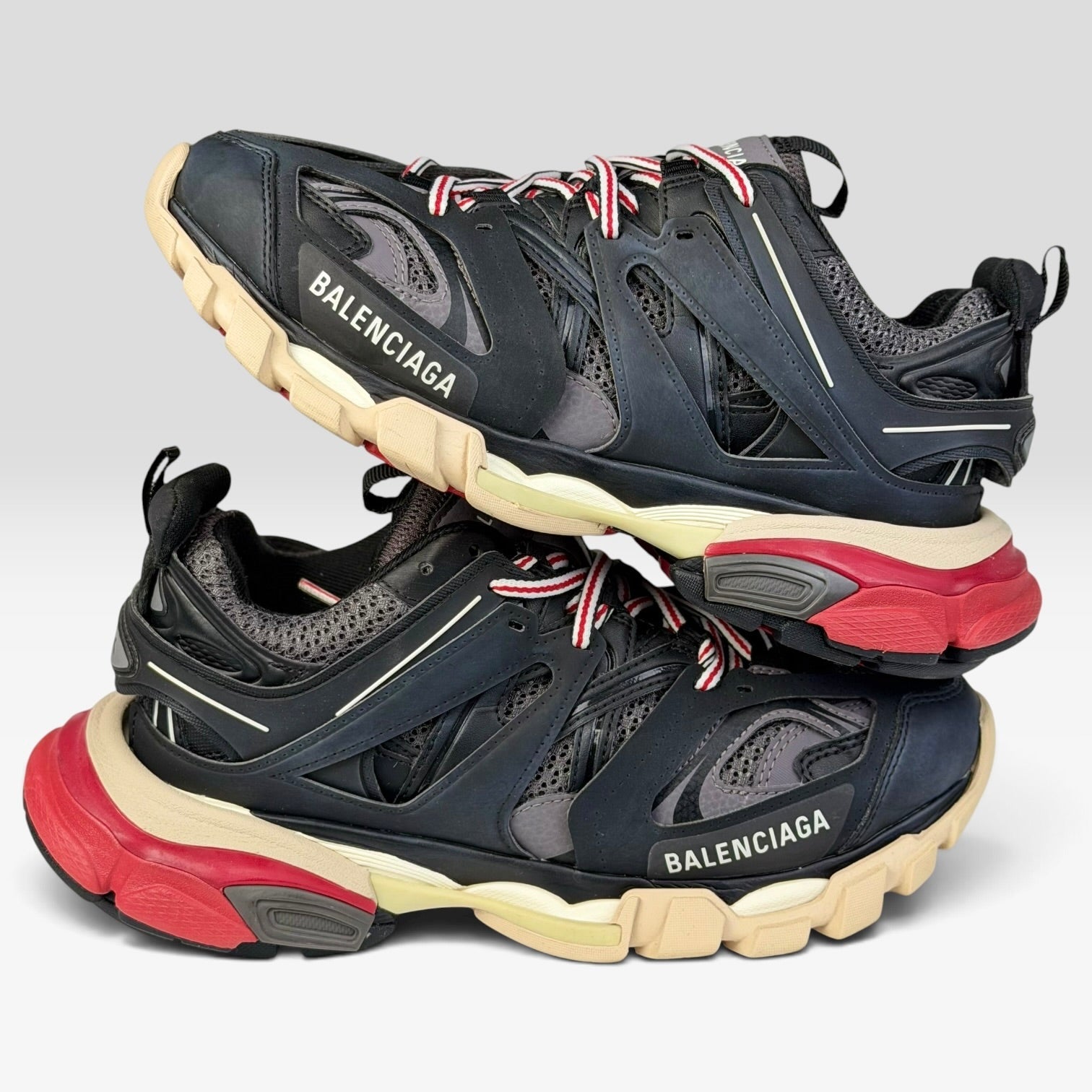 V STEALS Balenciaga Track Bred sneakers in black and red with technical mesh, layered caging, and chunky lug soles.