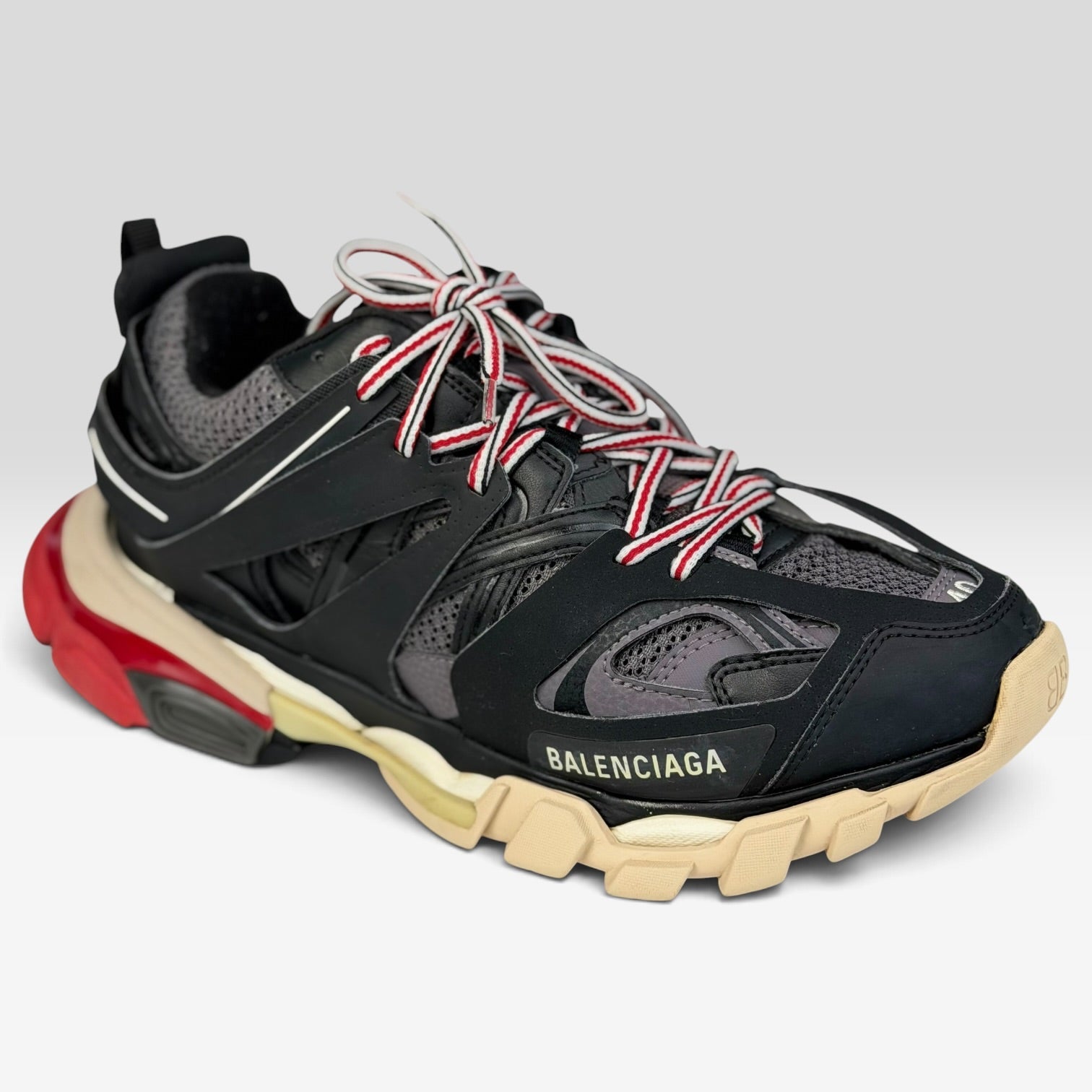 V STEALS Balenciaga Track sneakers in black and red with technical mesh, layered caging, and a chunky lug sole.