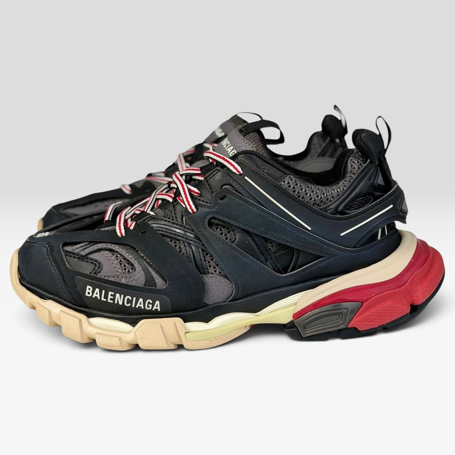 V STEALS Balenciaga Track Bred sneakers in black and red with technical mesh, layered caging, and a chunky lug sole.