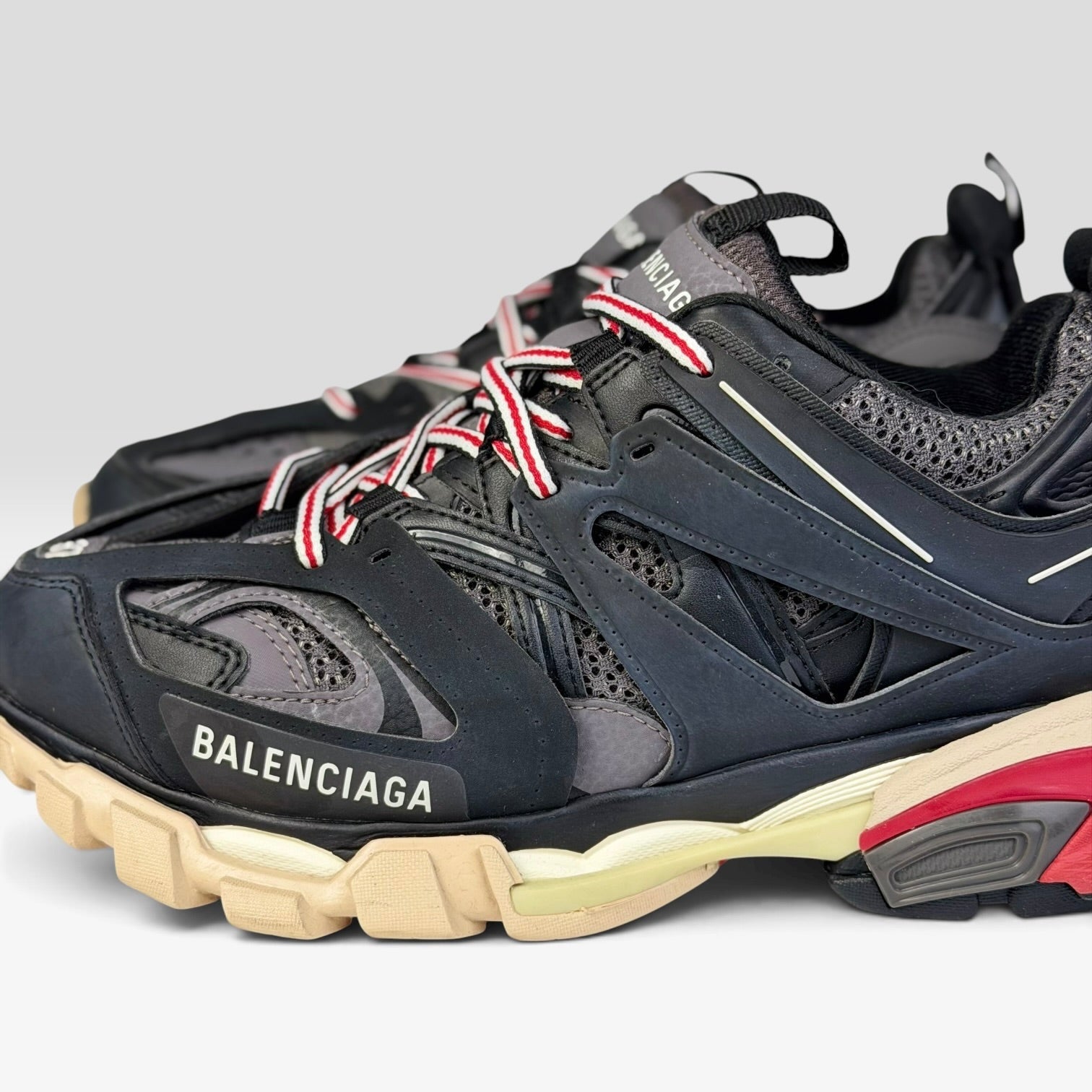 V STEALS Balenciaga Track Bred sneakers in black and red with technical mesh, layered caging, and chunky lug sole.