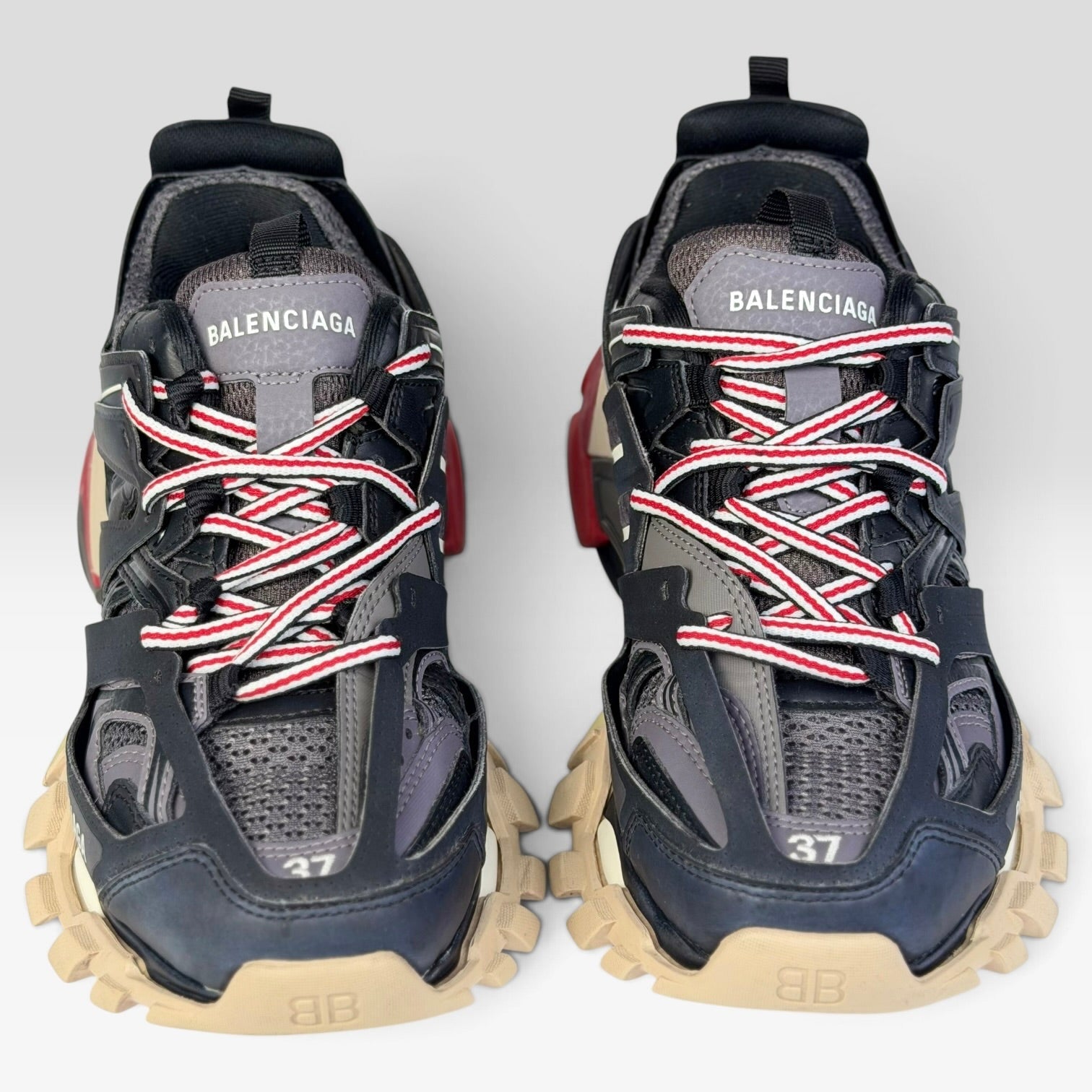 V STEALS Balenciaga Track sneakers in black and red with technical mesh, layered caging, and chunky lugged soles.