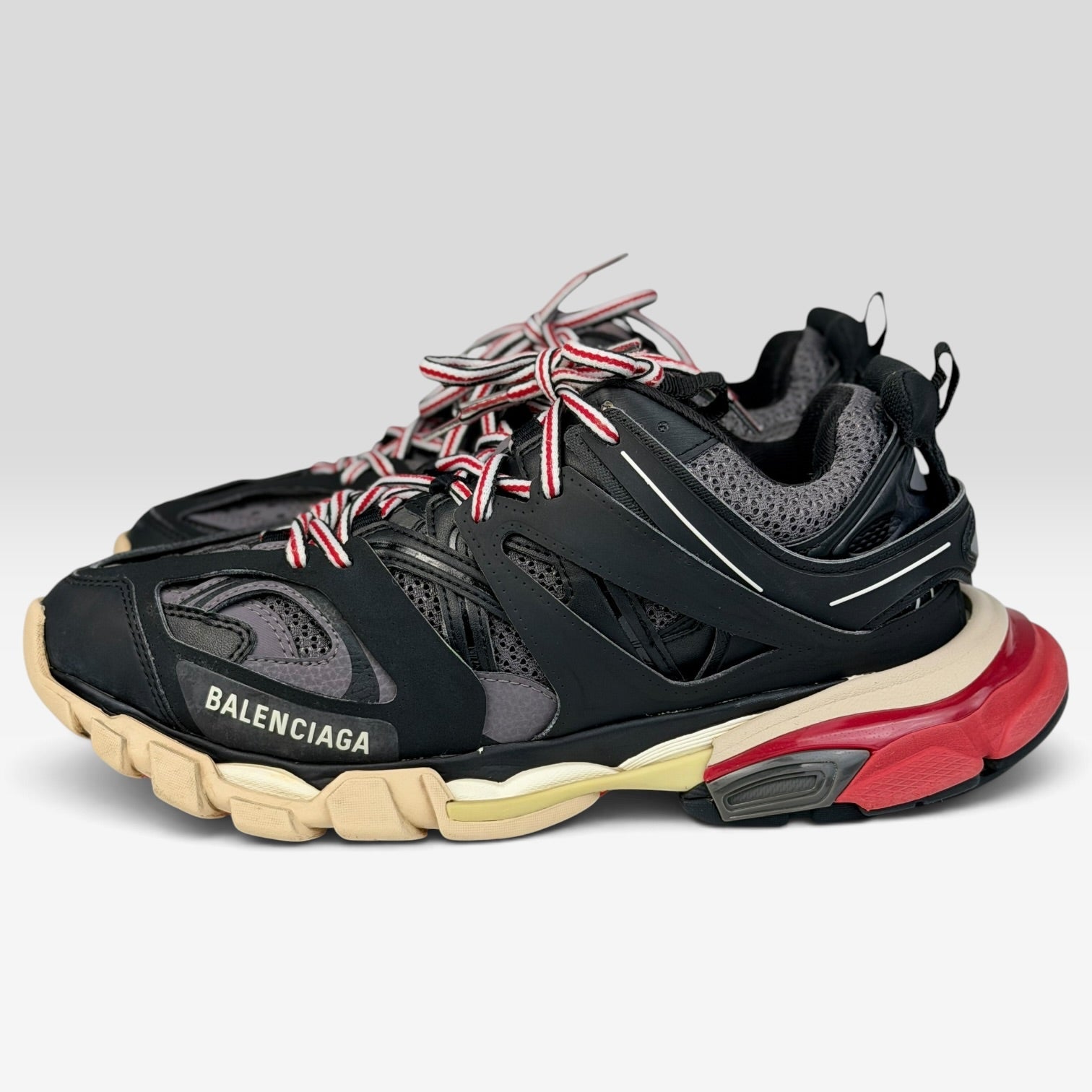 V STEALS Balenciaga Track sneakers in black and red with technical mesh, layered caging, and a chunky lug sole.
