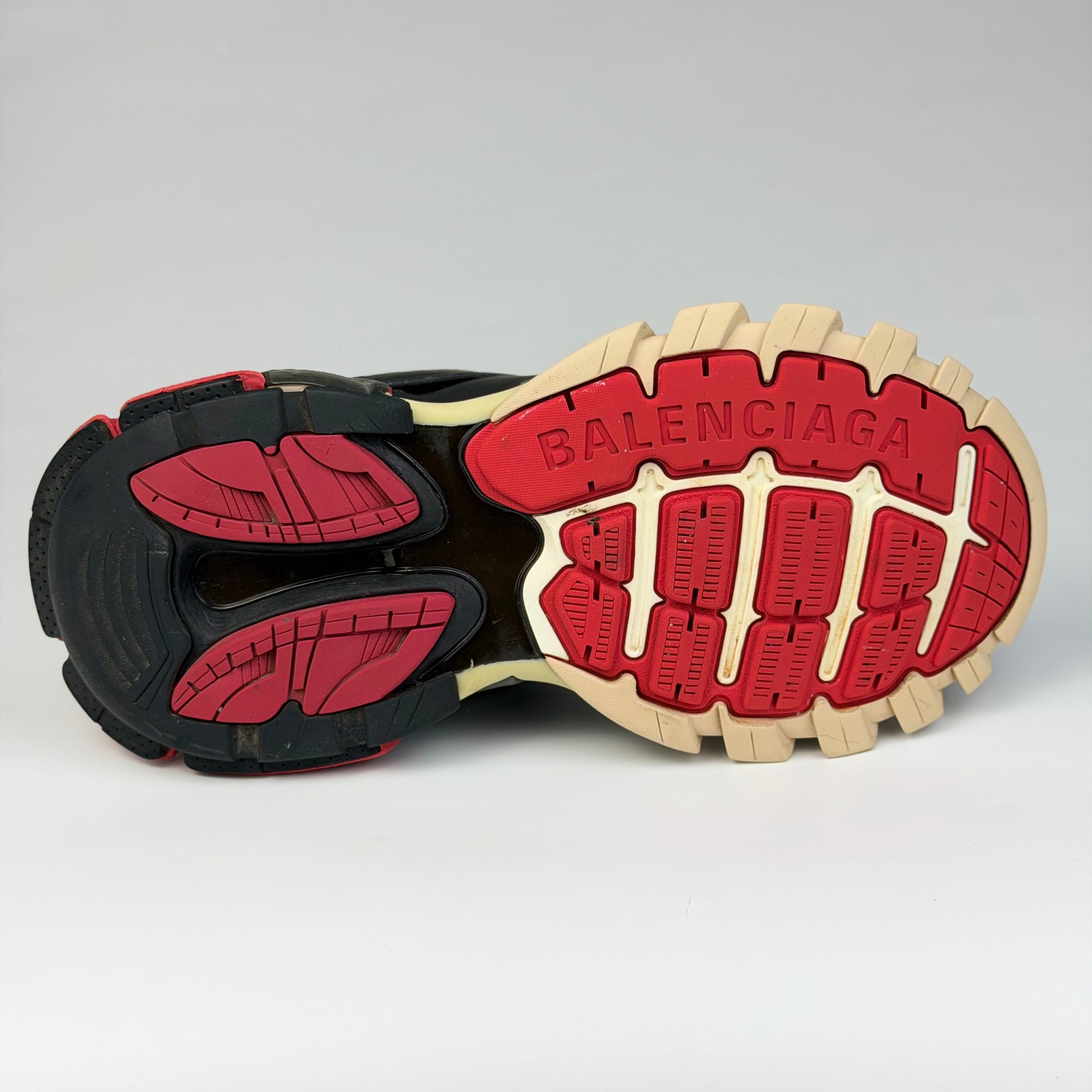 V STEALS Balenciaga Track sneaker outsole in red, black, and beige with aggressive lug tread and embossed logo
