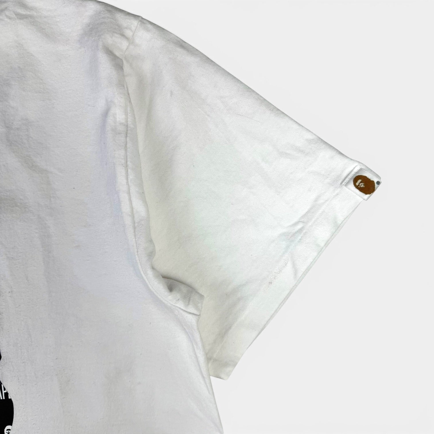 V STEALS white BAPE cotton t-shirt sleeve featuring a small Ape Head logo patch on the arm