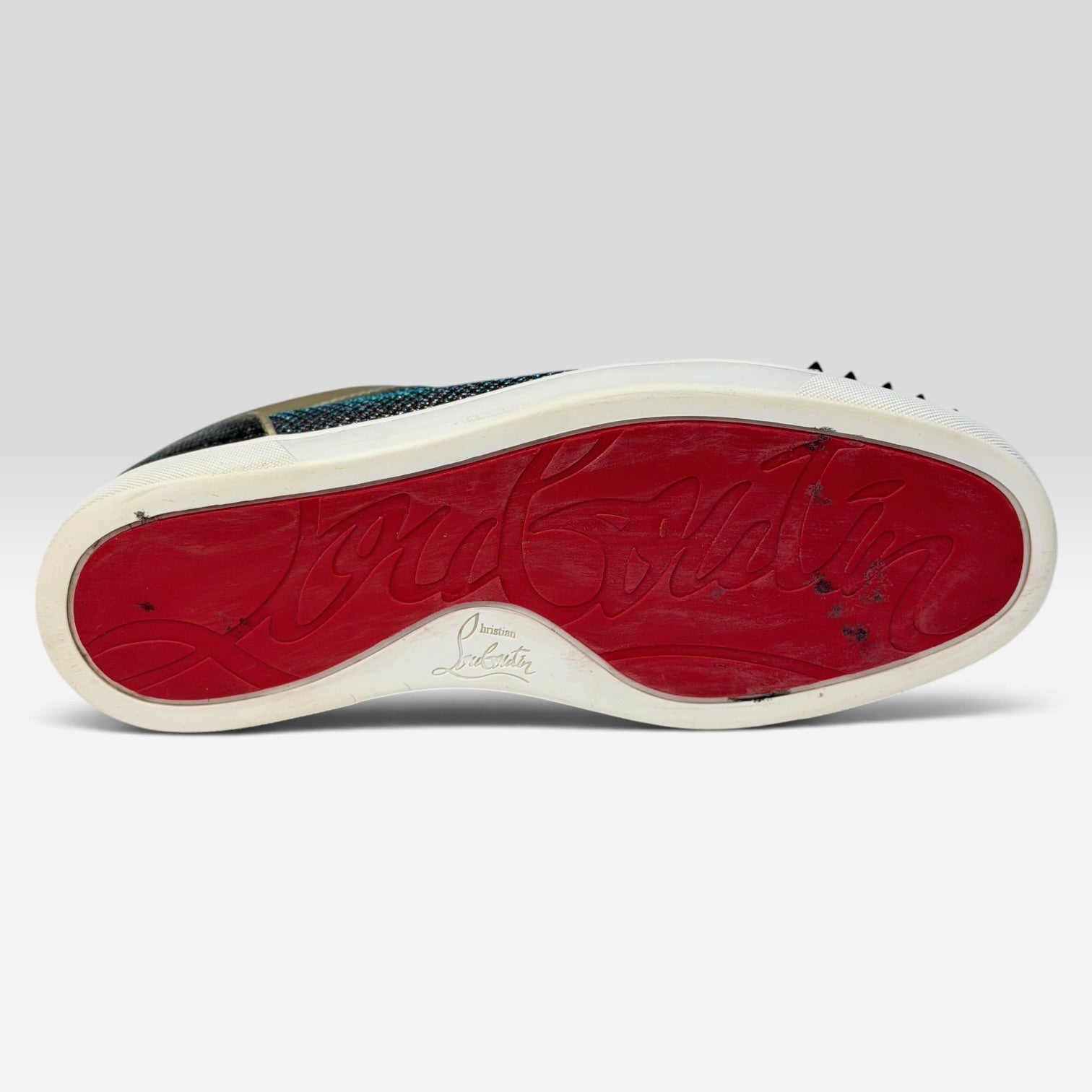V STEALS Christian Louboutin Louis Junior sneaker featuring the iconic red rubber sole with signature branding.