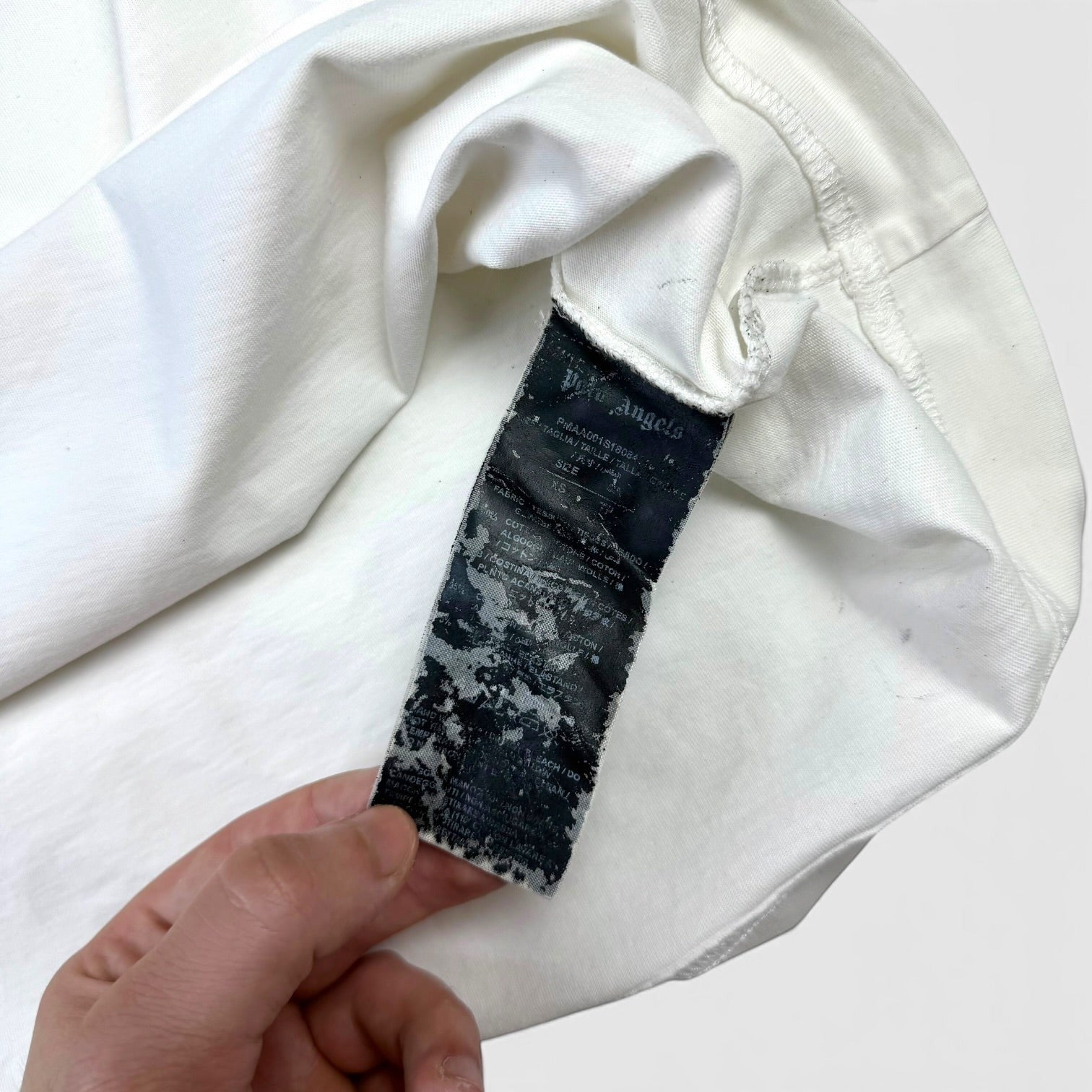 V STEALS Palm Angels white cotton t-shirt interior care label with brand details and size XS tag