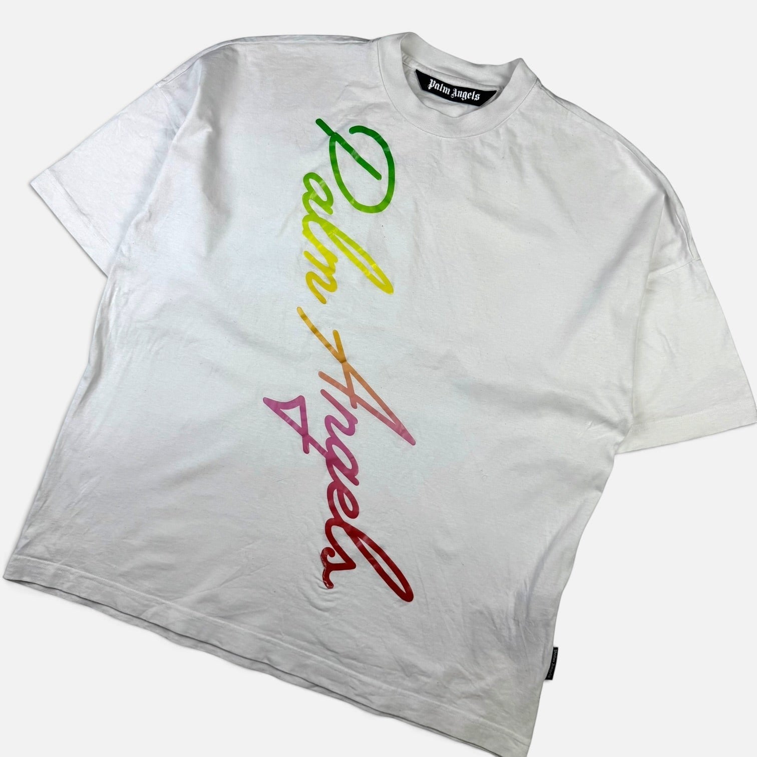 V STEALS white cotton Palm Angels t-shirt with a diagonal multicolored gradient script logo across the front.